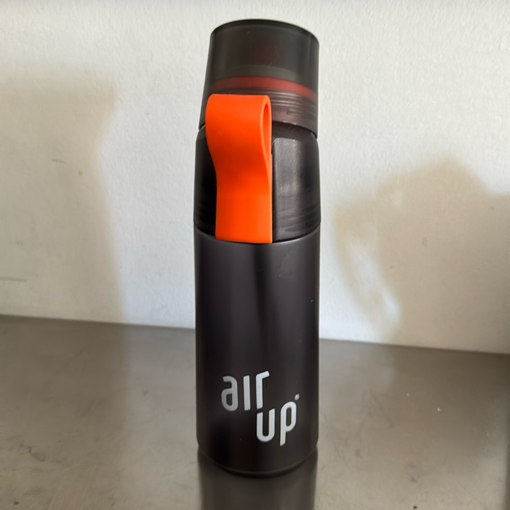 Grey air up® water bottle with orange top.